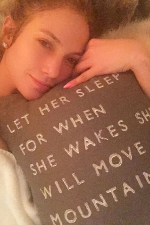Jennifer Lopez takes a selfie in bed.
